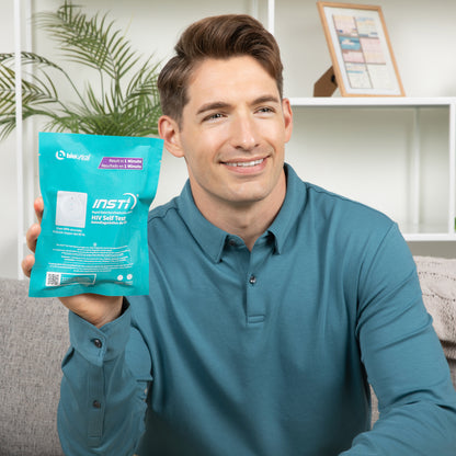 INSTI HIV Self Test kit packaging showing results in 1 minute, held by smiling man at home