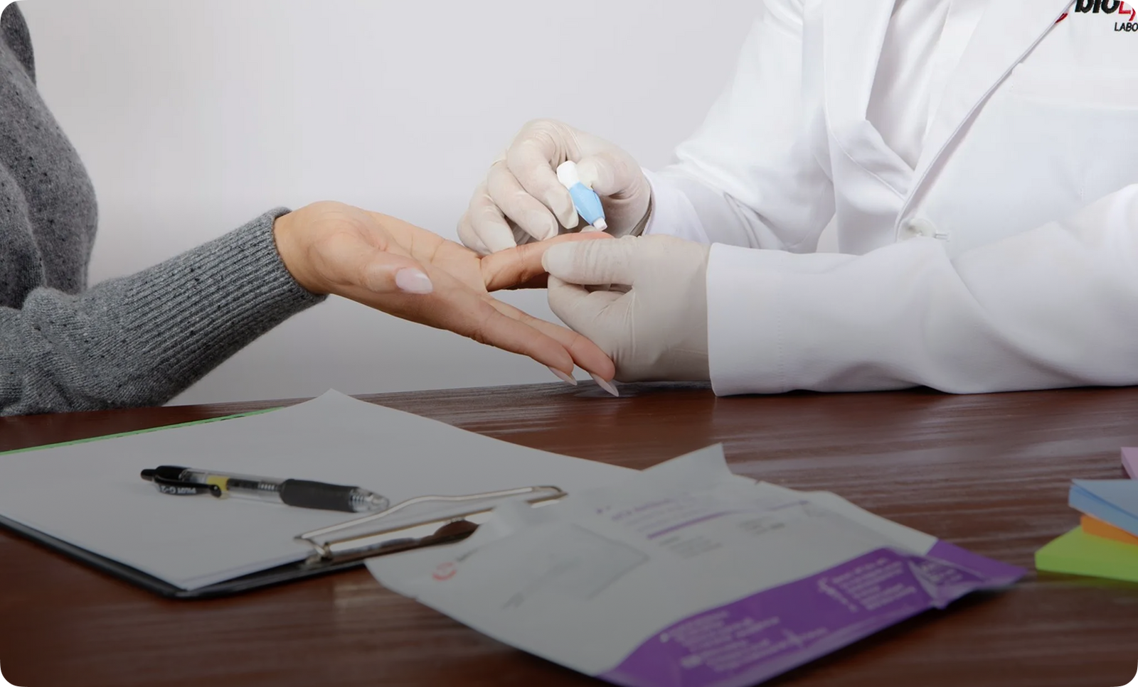 Healthcare professional performing fingerstick blood collection for rapid HIV test on patient